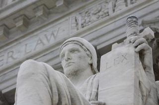 Statue holding up a tablet with the words "LEX"