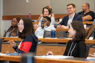 7 happy students sitting in a classroom